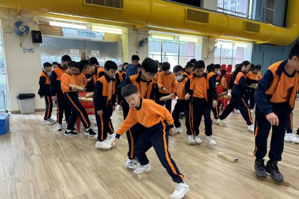 「木磚過河」活動鬥智鬥力，同學們要思考各種方法，讓木磚擺放到前方位置，但腳不能碰到地面，用最快的速度跨過「河流」。