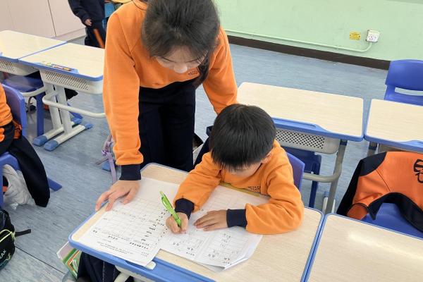 學生專心地練習書寫中英文默書的詞語。