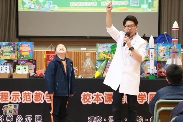 學生抬頭觀看模型火箭升空。